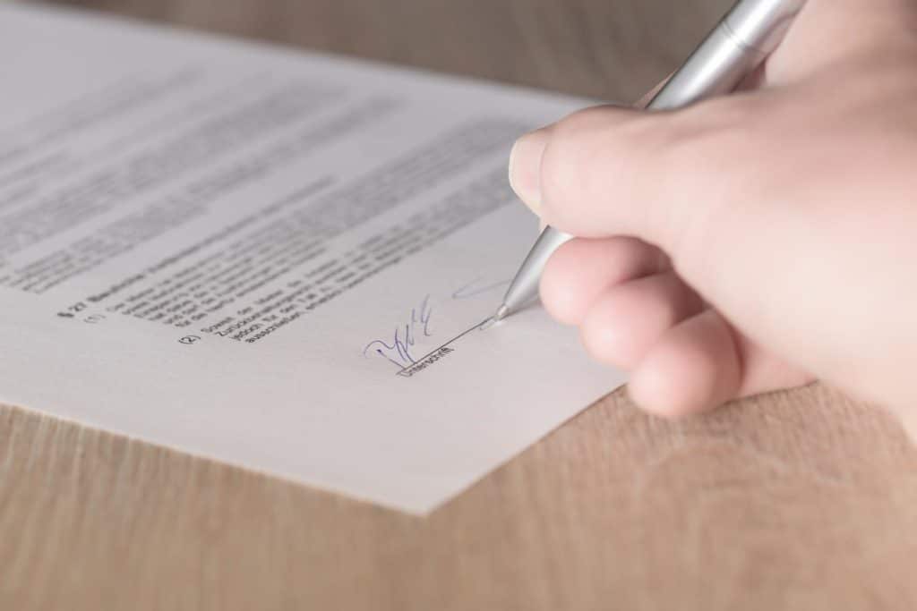 Обе стороны подписывают договор купли-продажи недвижимости в присутствии нотариуса